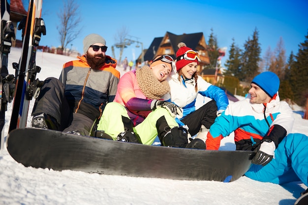 Quatro amigos com snowboarders na neve