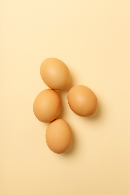 Quatro ovos isolados na superfície amarela