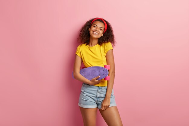 Que bom que adolescente com cabelo encaracolado posando em uma camiseta amarela