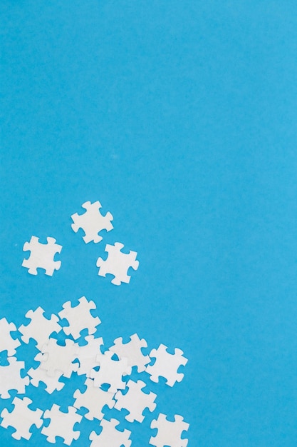Foto grátis quebra-cabeças brancos sobre um plano de fundo azul
