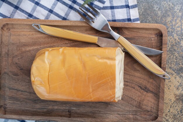 Queijo amarelo orgânico na placa de madeira.