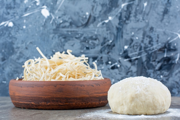 Foto grátis queijo cecil em uma tigela ao lado da massa, na mesa de mármore.