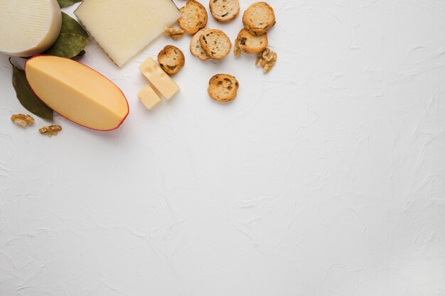 Foto grátis queijo; fatia de pão e noz sobre superfície texturizada branca