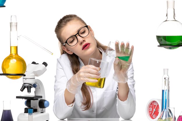 Química feminina de frente para o terno médico, misturando diferentes soluções no fundo branco.