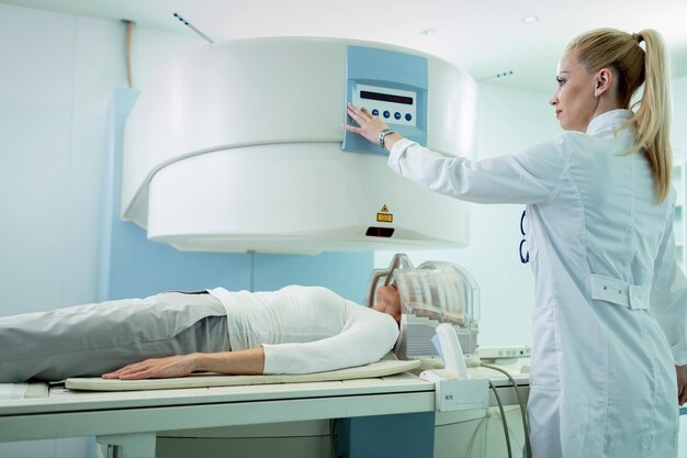 Radiologista ajustando o scanner de ressonância magnética antes do exame médico de um paciente que está fazendo uma varredura cerebral no hospital