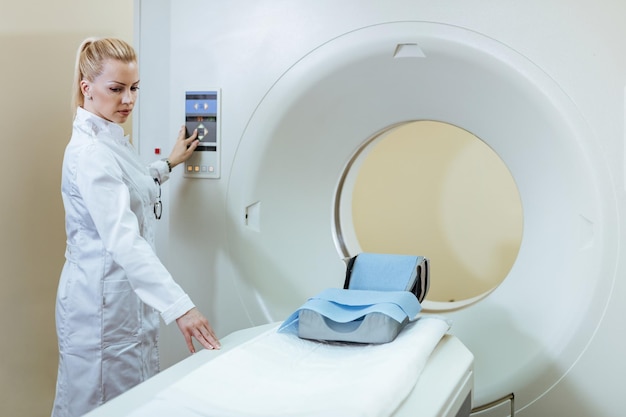 Radiologista feminino preparando o scanner CT para exame médico de um paciente