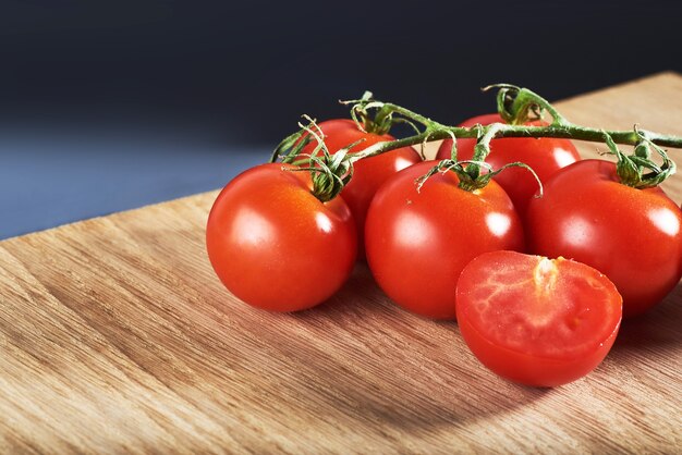 Ramo de tomate cereja vermelho orgânico de madeira.