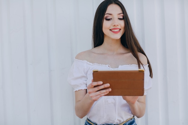 Rapariga de sorriso que toca na tela de um tablet