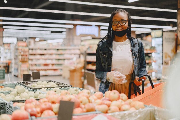 Rapariga negra com máscara a comprar comida