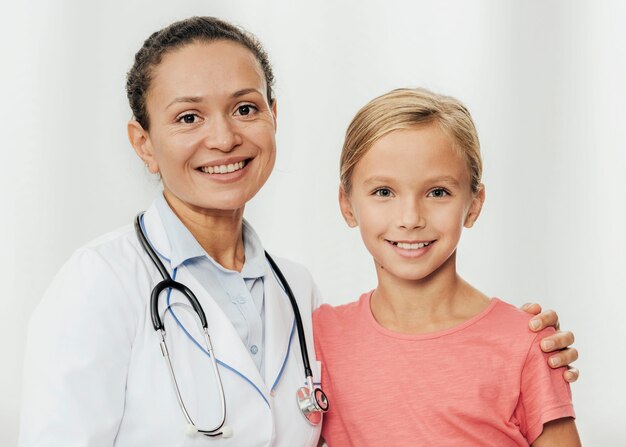 Rapariga sorridente com tiro médio e médico posando