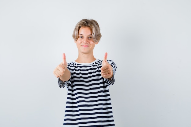 Rapaz adolescente mostrando os polegares em t-shirt e parecendo alegre. vista frontal.