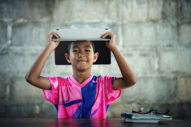 Rapaz asiático usando laptop na mesa, voltar a escola