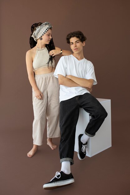 Rapaz e rapariga adolescente da moda a posar juntos