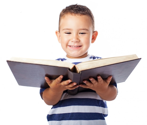 Foto grátis rapaz pequeno que sorri com um livro aberto