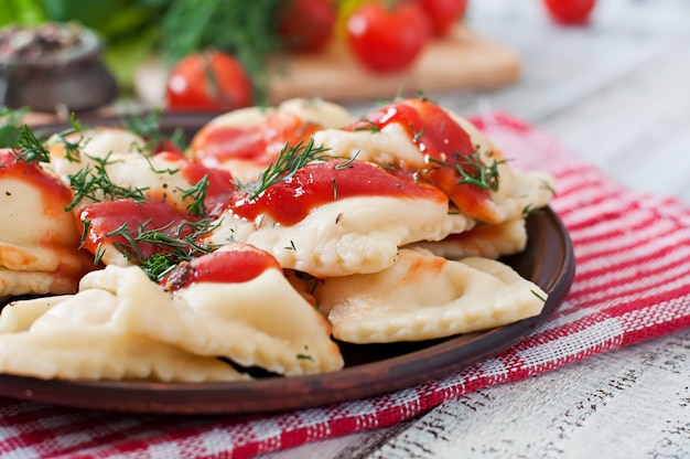 Foto grátis ravioli delicioso com molho de tomate e endro