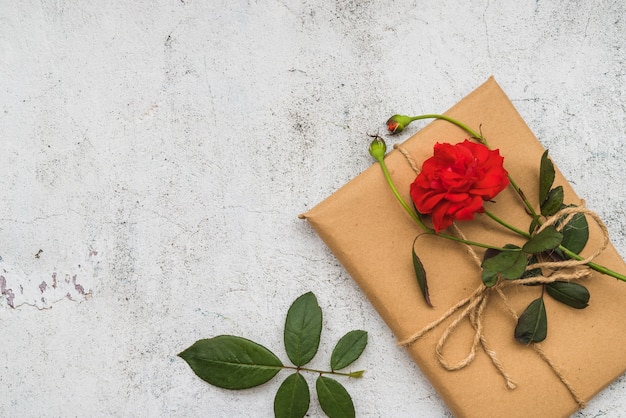 Foto grátis re flor rosa na caixa de presente embrulhado sobre o antigo fundo branco