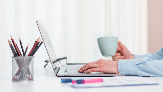 Área de trabalho de escritório com laptop e uma xícara de café