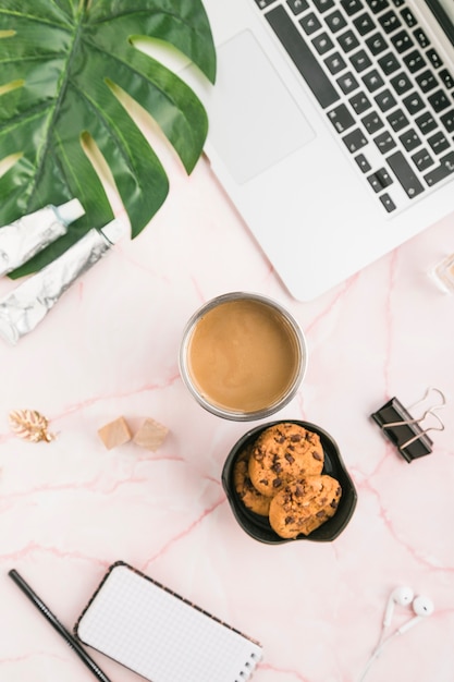 Área de trabalho de escritório com uma xícara de café e biscoitos