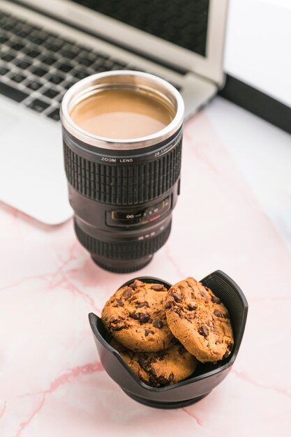 Área de trabalho de escritório com uma xícara de café e biscoitos