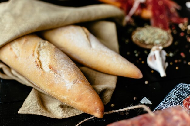 Recém-assados ​​baguete francesa com iguarias de carne em uma mesa de piquenique