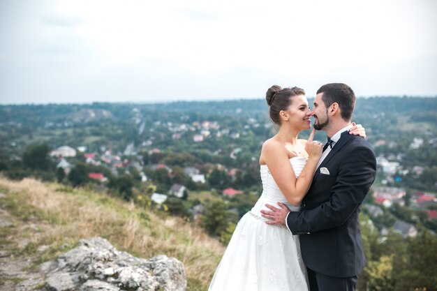 recém-casados ​​alegre que levanta ao ar livre