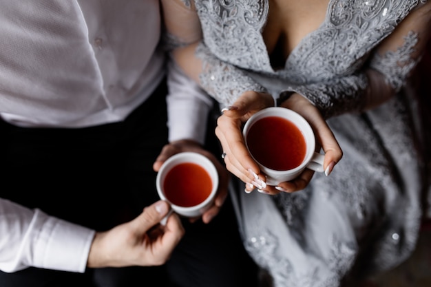 Foto grátis recém-casados mantêm o chá quente