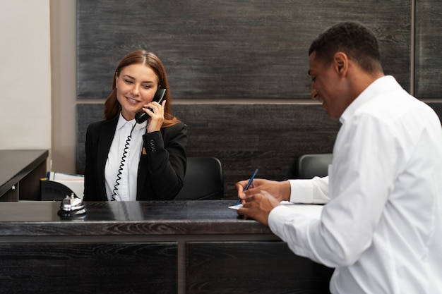 Recepcionista em terno elegante durante o horário de trabalho com o cliente