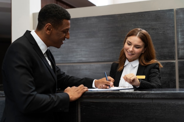 Foto grátis recepcionista em terno elegante no trabalho com o cliente