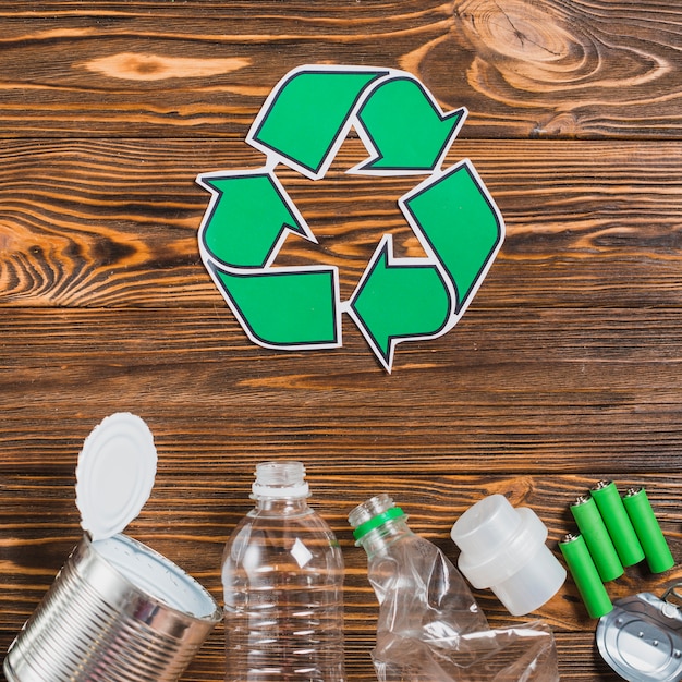 Reciclar o ícone com o produto de reciclagem no cenário texturizado de madeira