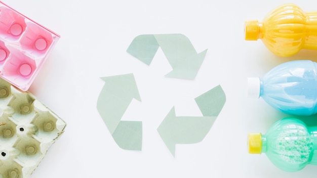 Foto grátis recicle o logotipo com garrafas e papelão