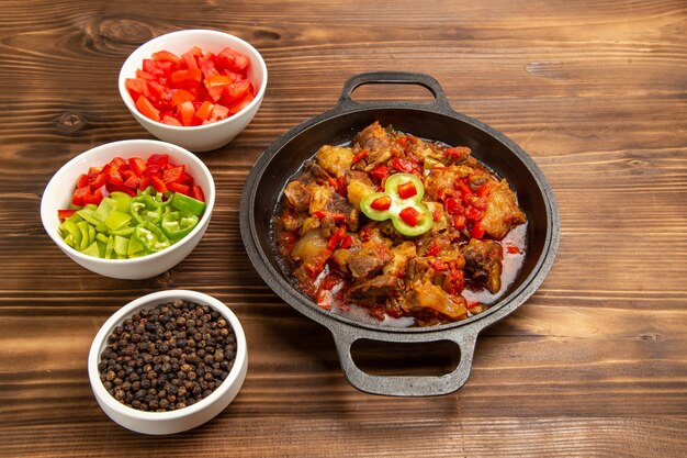 Refeição de vegetais cozidos com salada fatiada de pimentão na mesa marrom