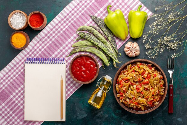 Refeição de vegetais fatiados em fatias deliciosa refeição de feijão com azeite e temperos na mesa azul