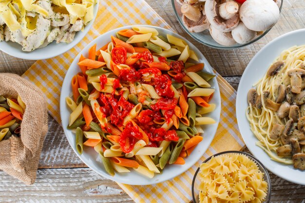 Refeições de macarrão em pratos com macarrão cru, cogumelos