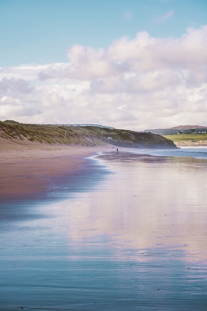 Reflexo do céu no mar à beira da praia na Cornualha, Inglaterra