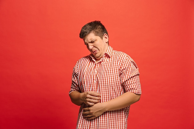 Foto grátis rejeite, rejeição, conceito de dúvida. homem duvidoso com expressão pensativa, fazendo escolhas. jovem emocional. emoções humanas, conceito de expressão facial. frente. estúdio. isolado em vermelho moderno