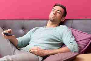 Foto grátis relaxed young handsome man watching tv at home