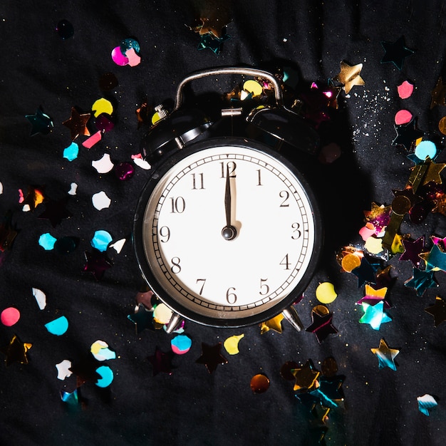 Foto grátis relógio de vista superior com confetes coloridos