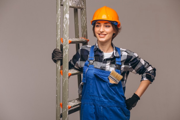 Reparador de mulher com escada de uniforme isolado