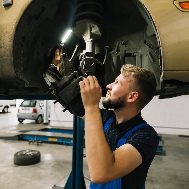 Foto grátis reparadores, examinando a estrutura da roda