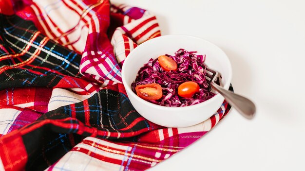 Repolho roxo e tomates na tigela na mesa