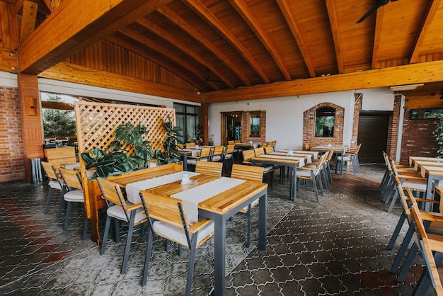 Restaurante ao ar livre com cadeiras e mesas de madeira