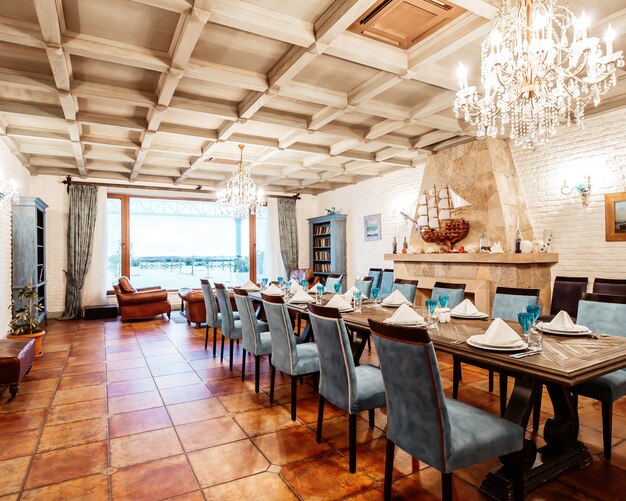 Restaurante room_ privado com cadeiras azuis, paredes brancas, lareira e janela larga