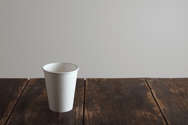 Foto grátis retire o vidro de papel em branco na mesa de madeira escovada envelhecida sozinho, isolado no fundo branco