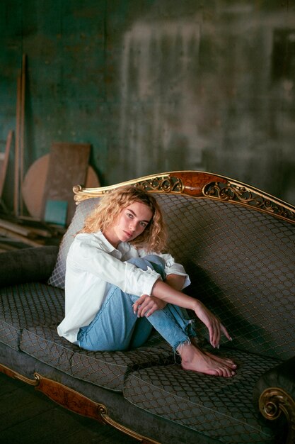Foto grátis retrato analógico de uma linda mulher posando dentro de casa em um sofá