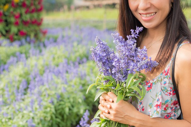 retrato ao ar livre de uma mulher envelhecida média bonita de Ásia. garota atraente em um campo com flores