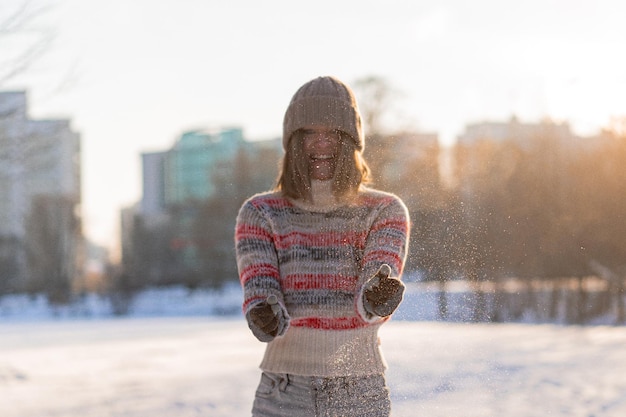 Retrato ao ar livre do retrato de inverno linda elegante feliz sorridente mulher jovem, mulher com chapéu de inverno, neve. curtindo os momentos de inverno