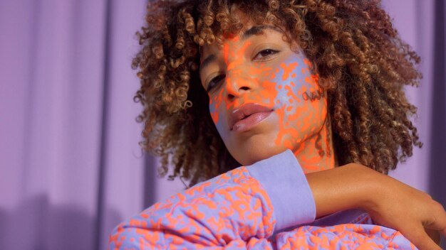 Retrato aproximado de mulher de raça mista com maquiagem neon, novo conceito de beleza, identidade autêntica Modelo com maquiagem criativa