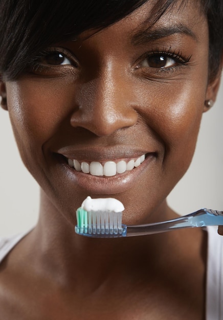 Retrato aproximado de uma mulher negra se preparando para limpar os dentes