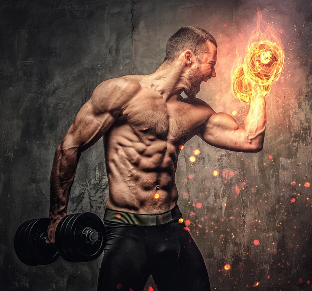 Retrato artístico de homem musculoso sem camisa com haltere em chamas.