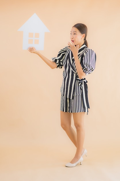 Retrato bela jovem asiática mostrar sinal de papel em casa ou casa